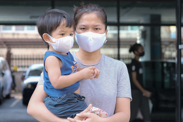 Single mom with kids boy in face mask outdoor city. Mother and child wear facemask during coronavirus and flu outbreak.