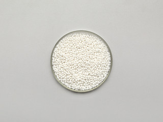 Top view of a bowl with white chemical granules.