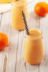 Tangerine and banana smoothie on wooden table