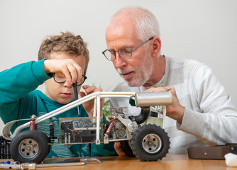 grandpa and son little boy repairing  model radio-controlled car