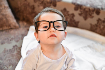 baby in black glasses. close-up. Poor vision in a child.