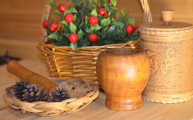 Still life pine cones pestle mortal  birch bark can wicker basket with berries on a wooden table