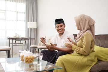 Fototapeta premium Asian couple muslim enjoying meal together breaking the fast in the evening together