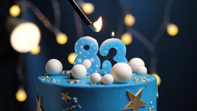 Birthday cake number 83 stars sky and moon concept, blue candle is fire by lighter and then blows out. Copy space on right side of screen if required. Close-up and slow motion