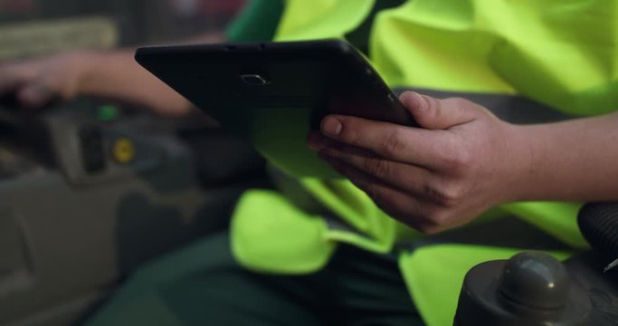 The engineer's hand holds the tablet and typing on it