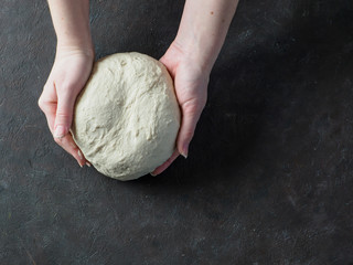 Woman hands kneading dough for bread.