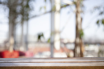 Wooden table top on a window glass blur with a view on the background. Street. To display product montage