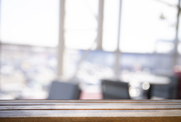 Wooden table top on a window glass blur with a view on the background. Street. To display product montage