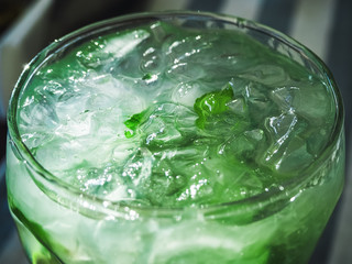 mojito cocktail with lime slices, mint leaves and ice closeup