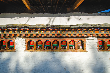 Prayer wheels on Buddhist temple wall, Bhutan