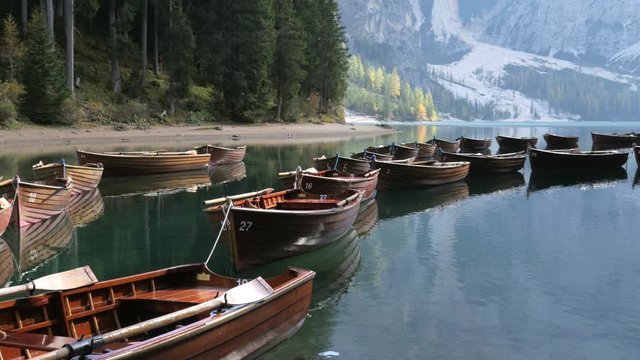 Beautiful landscape of Braies Lake, scenic wooden boats on the water, Alps Mountains Dolomites in Italy.