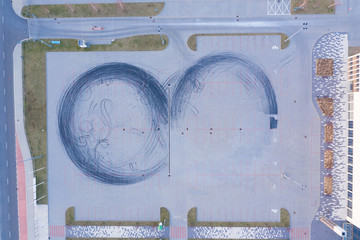 Car drift skid marks on empty parking lot, aerial drone top view