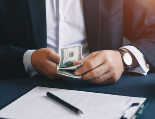 Businessman counting of dollar banknotes on work space. Business,finance,corrupt Concept.