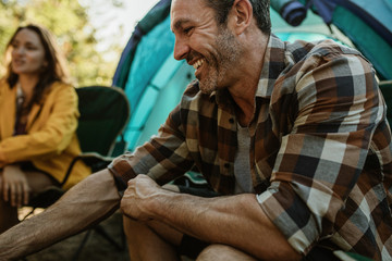Fototapeta premium Couple on camping sitting outside the tent