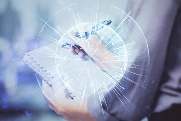 International business hologram over hands taking notes background. Concept of success. Multi exposure