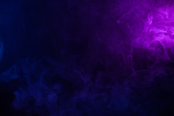 Soft clouds of colorful smoke on dark background