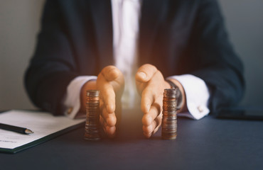 Concept of  saving and investing. Businessman separates stack coins. Property division. Divorce and legal services. - obrazy, fototapety, plakaty