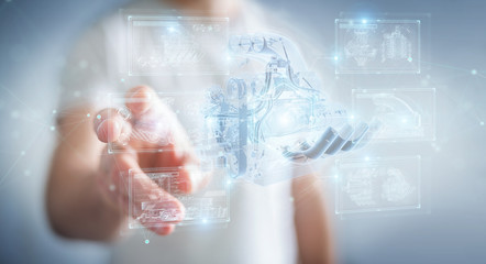 Businessman holding and touching wireframe holographic digital projection of an engine 3D rendering