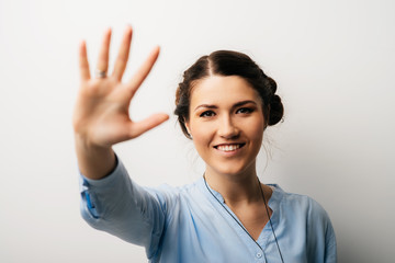 Pretty brunette girl showing five fingers