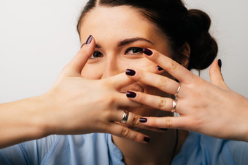 Obraz premium Pretty brunette girl covers her face with her hands