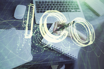 Cryptocurrency hologram over hands taking notes background. Concept of blockchain. Multi exposure