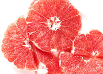 
sliced ​​red grapefruit on a white plate on a white background