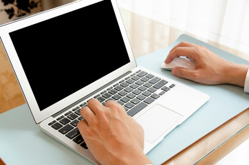 (Clipping Path) Businessman working on modern office. Closeup hands using contemporary notebook with blank monitor, texting keyboard. Work from home concept of global pandemic coronavirus, COVID-19.