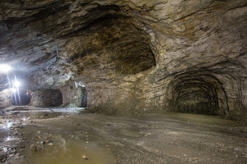 Underground gold mine shaft tunnel drift with rails and light