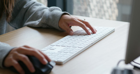 Woman type on desktop computer