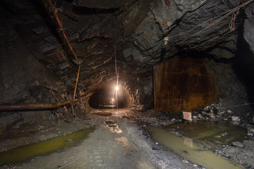 Fototapeta na wymiar Underground gold quartz mine shaft tunnel drift with light