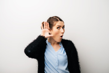 A woman can not hear with his hand near his ear. Isolated on a white background