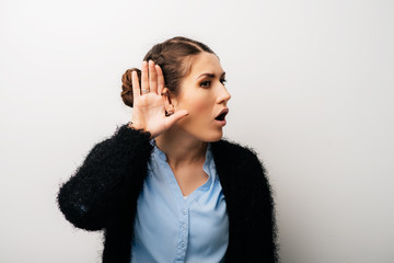 A woman can not hear with his hand near his ear. Isolated on a white background