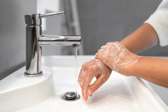 Hand Washing Lather Soap Rubbing Wrists Handwash Step Woman Rinsing In Water At Bathroom Faucet Sink. Wash Hands For COVID-19 Spreading Prevention. Coronavirus Pandemic Outbreak.