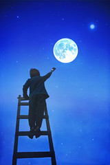Cute school boy, climbing latter, painting stars in the sky