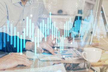 Multi exposure of chart with man typing on computer in office on background. Concept of hard work.