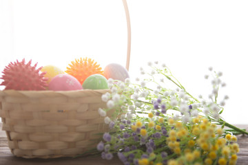 Virus model of Coronavirus disease COVID-19 with colorful easter eggs in basket with flowers on a...