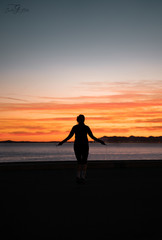 Fototapeta premium silhouette of a woman running on the beach at sunset