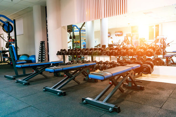 Fototapeta na wymiar Bench in an exercise room. Equipment and machines at the modern gym room fitness center.