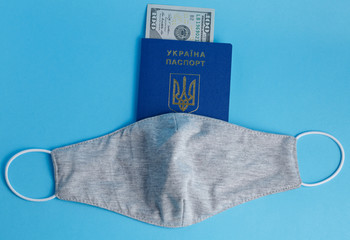 mask on a biometric passport inside the passport money banknote 100 dollars on a blue background medicine crown virus cvid 19
