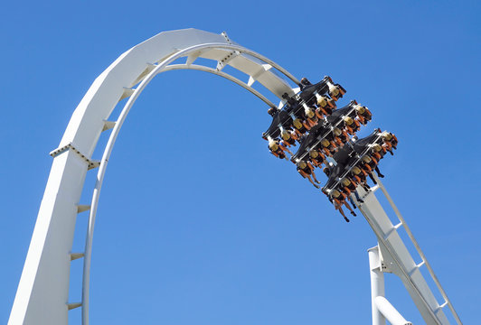 Rollercoaster Ride And Loop Against Blue Sky