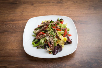 Fresh salad with grilled beef , arugula and tomato. Top view