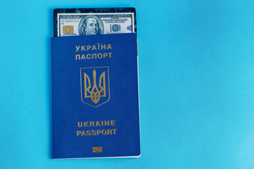 Ukraine passport with black dollar bank card on a blue background