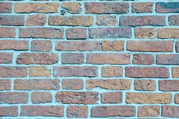 Old brick wall of weathered brick of different colors as a background