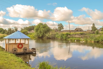 Rural landscape with  wooden gazebo by  river