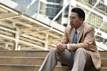 Smart business man sitting down  on the stair with city background
