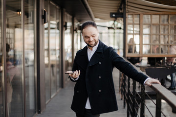 Fototapeta premium Portrait of fashionable well dressed man with beard posing outdoors