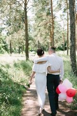 bride and groom walking in the forest