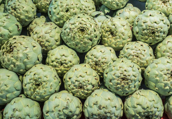 Artichokes symmetrically stacked in a vegetable stand
