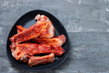 marinated meat on black dish on ceramic background