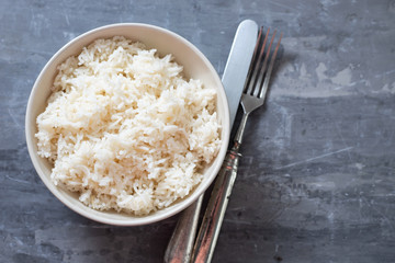 boiled rice in the small bowl on ceramic background